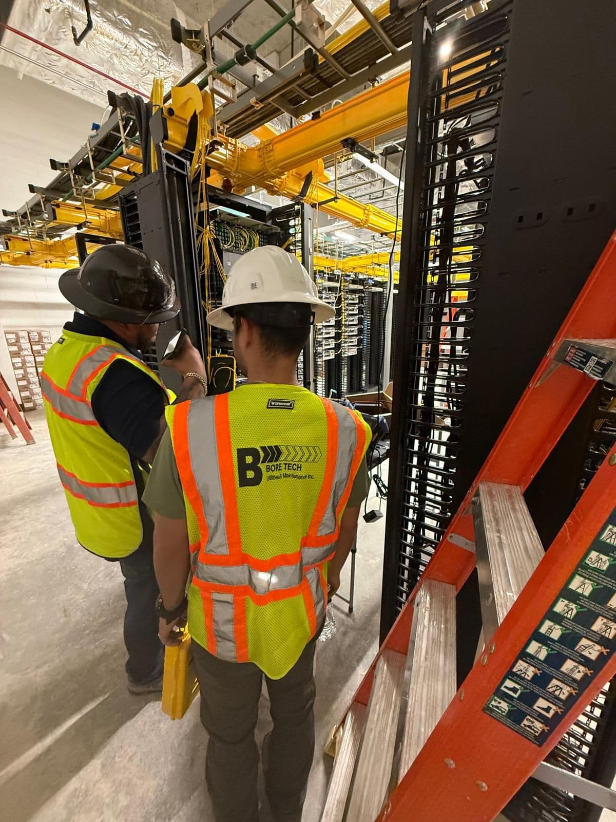 Bore Tech field crew reviewing utility infrastructure inside a technical equipment room.