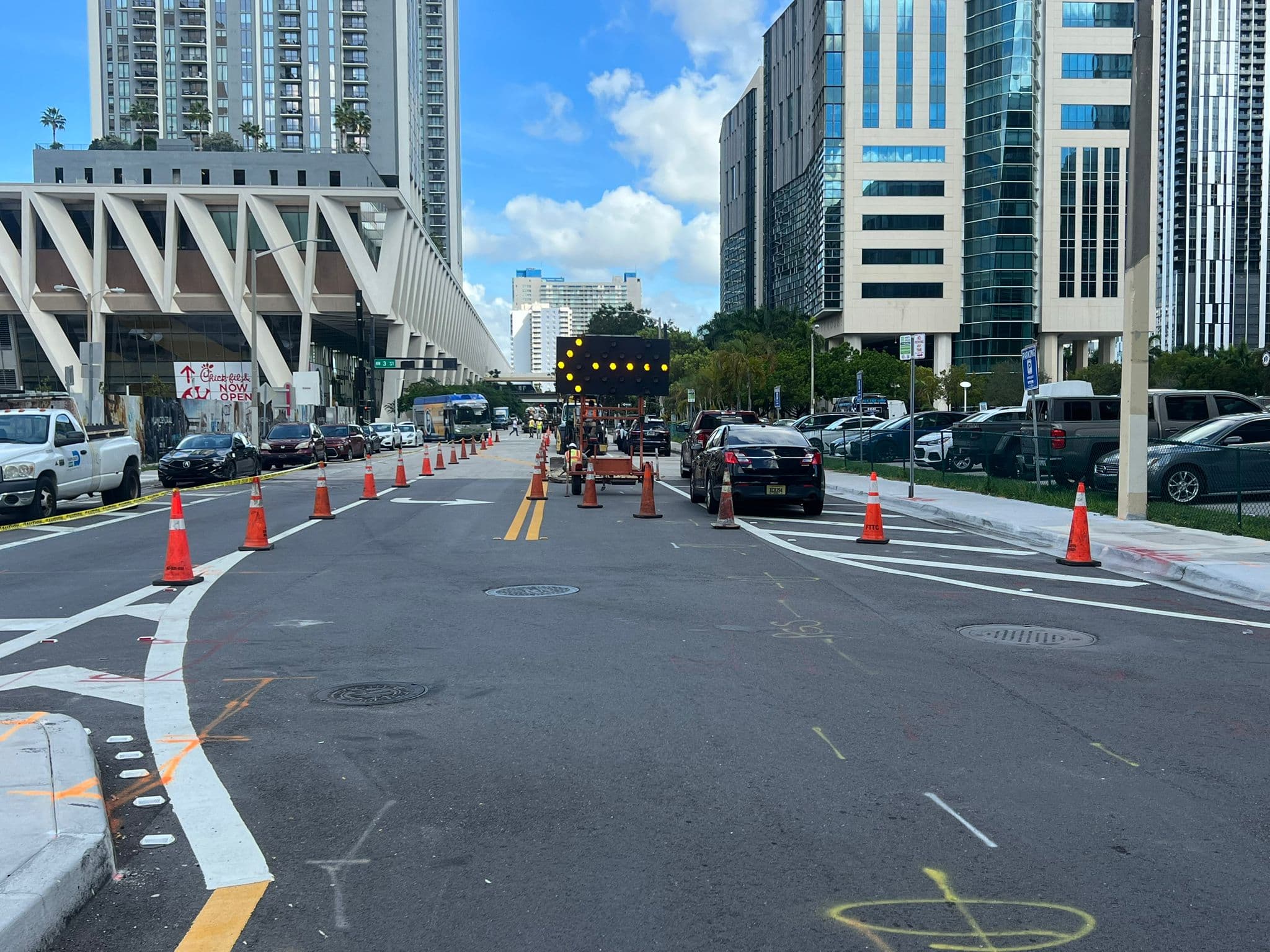 Urban roadway work zone with traffic cones and safety control equipment.